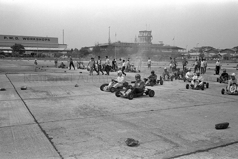Go Kart racing at Kallang Park held in conjunction with Singapore's "Tourist Week", a joint effort by Singapore Tourist Promotion Board and a number of voluntary organisations. In the background is old Kallang Airport terminal building which serves as headquarters of the Peopleâ€™s Association. The Go Kart teams on the island competed for Tourist Week trophy at the event.