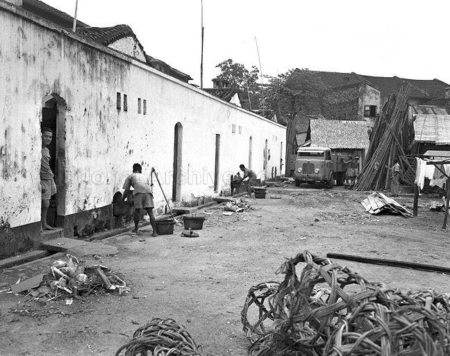 Night-soil collectors in a back alley in 1952. Source: NAS