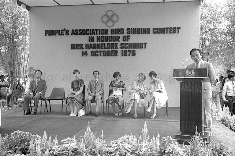 People's Association (PA) Executive Director Lim Chin Tiong speaking at opening of bird singing contest organised by the PA. The contest at Toa Payoh Gardens is held in honour of Mrs Hannelore Schmidt (seated, second from left), wife of West German Chancellor Helmut Schmidt who is on a two-day state visit to Singapore. Also present are Member of Parliament for Toa Payoh Eric Cheong Yuen Chee (seated, third from left) and Chief of Protocol at Ministry of Foreign Affairs Tan Keng Jin (seated, extreme left).