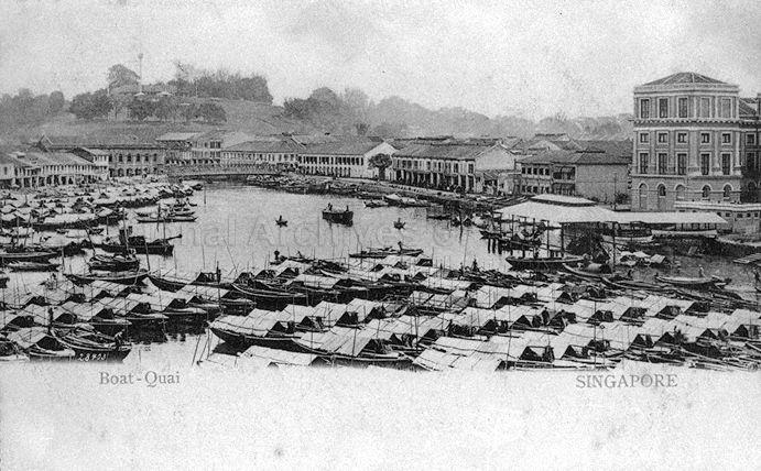View of Boat Quay looking towards Fort Canning Hill, Singapore. The covered landing stage on the right was the site of the original Hallpike Boatyard where boat building and repairs were carried out from 1823 to late 1860s.