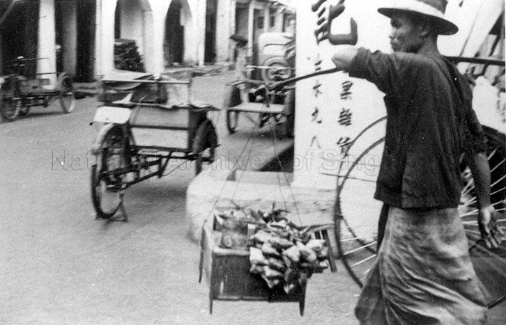 Photograph of satay hawker carrying his wares along the street, taken by Gavin G Wallace