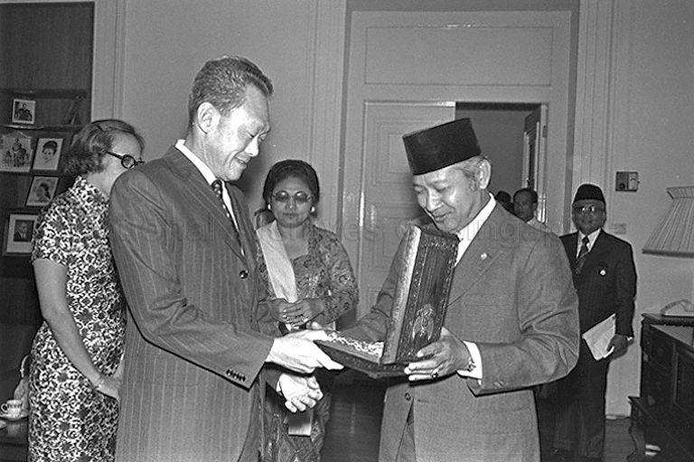 Prime Minister Lee Kuan Yew receiving the Bintang Republik Indonesia Adi Pradana medal from President Suharto of Indonesia during his courtesy call on the Indonesian leader at Istana Drawing Room. Looking on are Mrs Tien Suharto and Mrs Lee Kuan Yew.