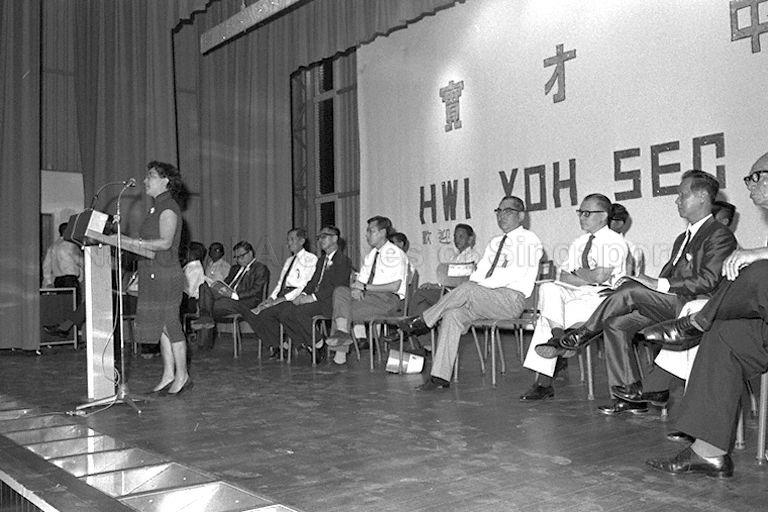 School official delivering speech during Hwi Yoh Secondary School's official opening by Member of Parliament for Jalan Kayu Hwang Soo Jin (seated fourth from right).