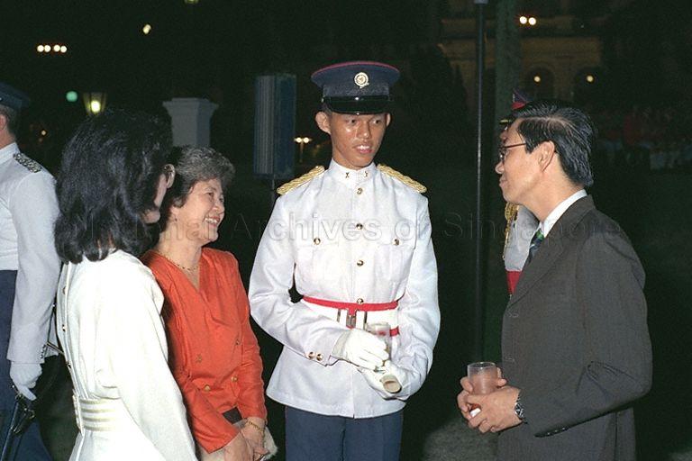 President's Scholar Chan Chun Sing and his mother, Madam Kwong Kait Fong (red outfit) chatting with guests at reception following the President's Scholarship awards presentation at Istana.