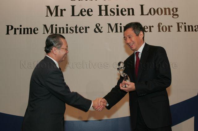 Guest of Honour Prime Minister and Minister for Finance Lee Hsien Loong presenting token of appreciation to Permanent Secretary to Ministry of Finance and outgoing Head of Civil Service Lim Siong Guan during annual dinner for the Administrative Service, the Civil Service's elite wing, at Conrad Centennial Singapore. Mr Lim relinquished his appointment as Head of Civil Service on 1 April 2005.