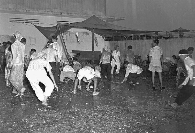 Strikers and Chinese students picking up stones from the ground to retaliate after the police used fire hoses to disperse them at the Hock Lee Bus Riots