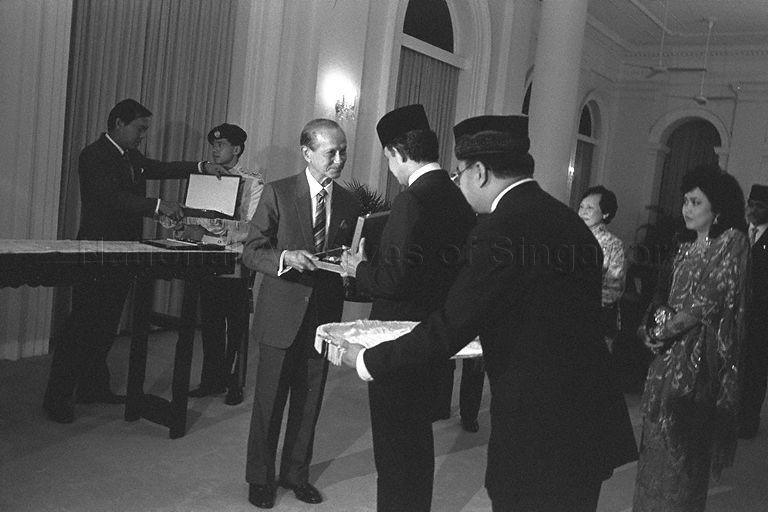 Presentation of State awards between Sultan Hassanal Bolkiah of Brunei and President Wee Kim Wee at Istana during the Sultan's first state visit to Singapore. Looking on is consort of Sultan Hassanal Bolkiah, Raja Isteri Pengiran Anak (right).