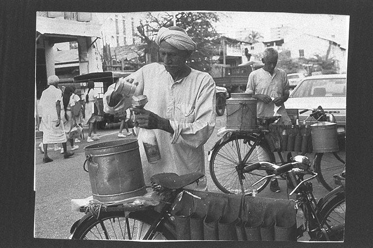 Indian man selling goat's milk from a bicycle at Serangoon Road in Little India