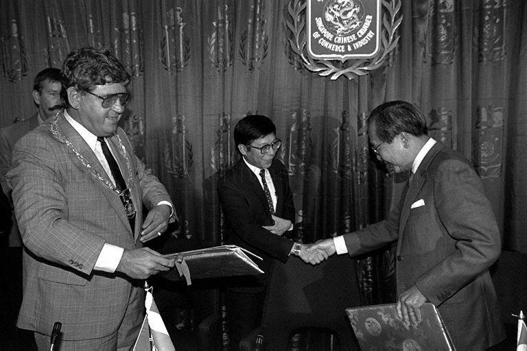 President of Singapore Chinese Chamber of Commerce and Industry (SCCCI) Tan Eng Joo (right) shaking hands with Minister of State for Communications and Information and Trade and Industry Mah Bow Tan after signing ceremony of 99-year land lease of Singapore Trade and Distribution Centre in Rotterdam. Looking on is Mayor of Rotterdam Dr A Peper.