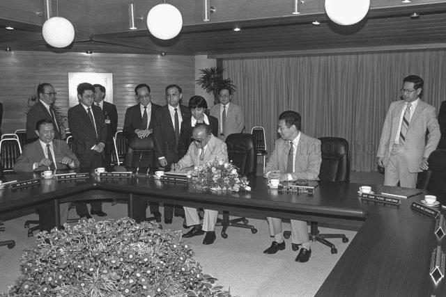 China's President Yang Shangkun, who is in Singapore for a four-day state visit, signing guest book upon arrival at Jurong Town Corporation for a visit. On the right are Deputy Prime Ministers Ong Teng Cheong (standing) and Brigadier-General Lee Hsien Loong.