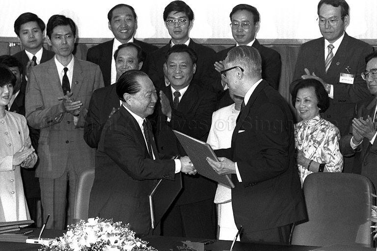 Chairman of China's Association for Relations Across the Taiwan Straits (ARATS) Wang Daohan (left) and Chairman of Taiwan's Straits Exchange Foundation (SEF) Koo Chen-fu sealing the agreements with a handshake during a 20-minute signing ceremony held at the auditorium of Neptune Orient Lines (NOL) Building in Alexandra Road