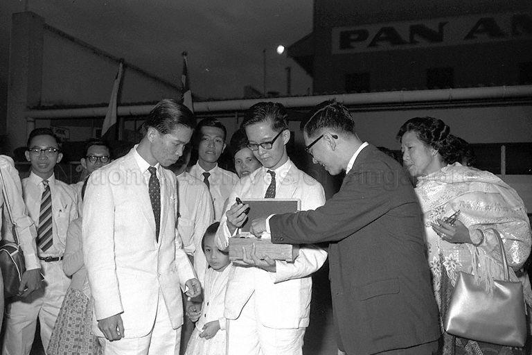 Tan Lian Ann (centre) holding the chess set that he won when he arrives at Paya Lebar Airport . He was placed second in the Australian Chess Championships held in Perth.