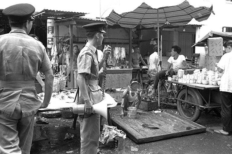 Public health inspectors checking on the hygiene of street hawkers and market vendors near Arab Street