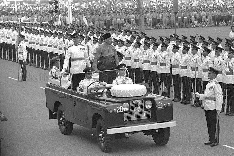 National Day 1963 at the Padang - Yang Di-Pertuan Negara of Singapore Yusof Ishak inspecting guard of honour in a Land Rover