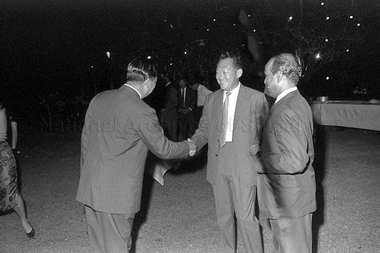 Prime Minister Lee Kuan Yew exchanging greetings with guest during Hari Raya Puasa reception hosted by Yang Di-Pertuan Negara Yusof Ishak at Istana