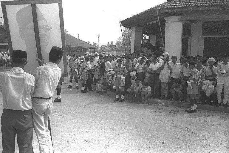 View of crowd waiting to welcome the arrival of Prime Minister of Malaysia Tengku Abdul Rahman who will be opening UMNO House