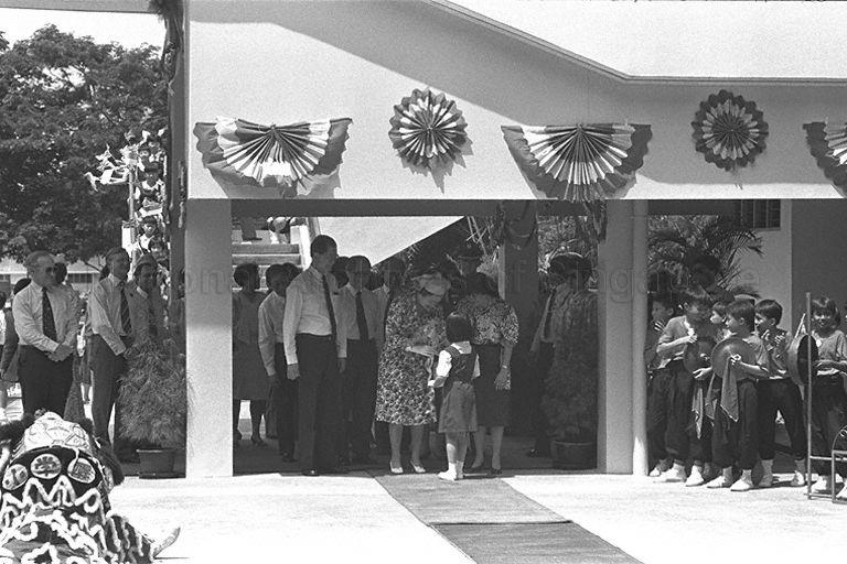 Eight-year old Huang Bingjie presenting a spray of orchids to Queen Elizabeth II upon her arrival at Townsville Primary School in Ang Mo Kio.  Looking on is Minister for Education and Minister-in-Attendance Dr Tony Tan and Senior Minister of State for Education Dr Tay Eng Soon.  The Queen is here on a three-day state visit at the invitation of President and Mrs Wee Kim Wee.