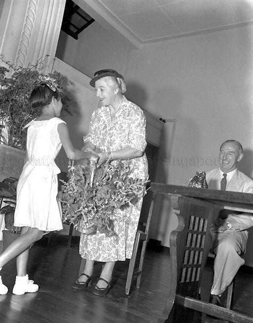 Assistant Educational Advisor to the Secretary of State for Colonies Freda Gwilliam receiving bouquet of flowers from student Grace Teo of Tanjong Katong Girls' School at the school's official opening