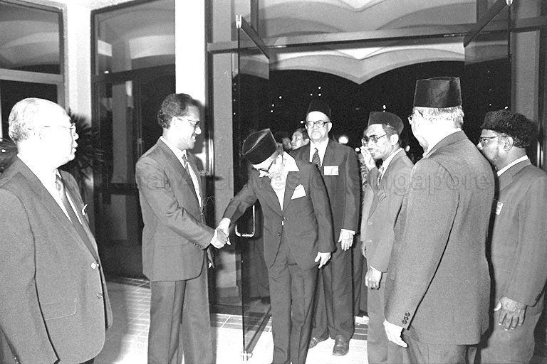 In the centre, behind the man greeting Dr Ahmad Mattar, is Professor Ahmad bin Mohamed Ibrahim. Professor Ahmad Ibrahim was a recipient of the Queen's Scholarship in 1936 and served as Singapore's first non-British Attorney-General. He was a key person in the merger talks with Malaya. He formulated the Administration of Muslim Law Act. He then served as Singapore's Ambassador to Egypt. After retirement, he joined the University of Malaya in Kuala Lumpur as its first Dean of its law faculty.