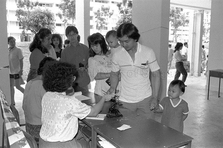 General Election 1988 - Parents bringing younger children to void deck poll station to cast their votes