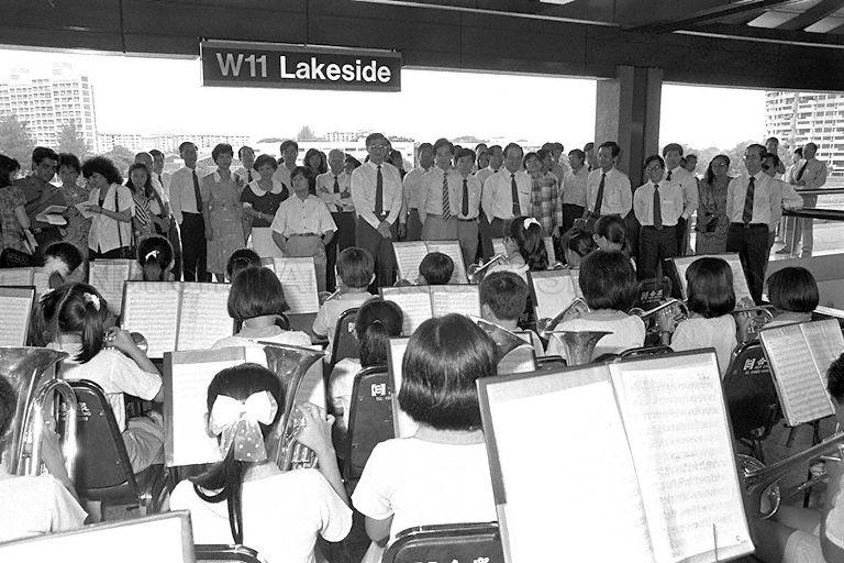 Minister for Communications and Information Dr Yeo Ning Hong, 11 VIPs (Very Important Persons) and 300 guests appreciating school band performance at Lakeside station. From right are (front) Member of Parliament (MP) for Boon Lay Goh Chee Wee, Minister of State for Communications and Information Mah Bow Tan, Dr Yeo, MP for Yuhua Yu-Foo Yee Shoon, Chairman of MRT Corporation (MRTC) Michael Fam, MP for Hong Kah Group Representation Constituency (GRC) Dr John Chen, Acting Health Minister Yeo Cheow Tong, MP for Hong Kah GRC Abdul Nasser Kamaruddin (back) and Executive Director of MRTC and Managing Director of Singapore MRT Lim Leong Geok.