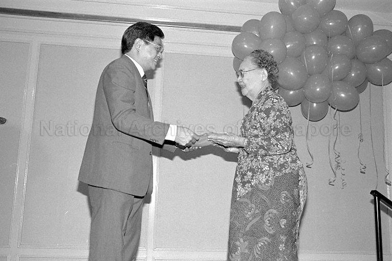 Khoo Ban Tian, on behalf of his father Khoo Teck Puat, presenting gifts to a senior citizen during Goodwood Group's charity party at York Hotel's Carlton Hall.