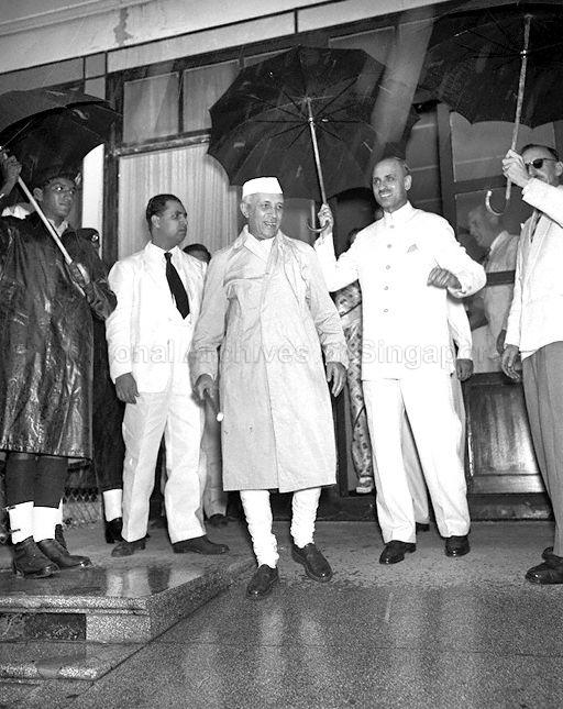 Prime Minister of India Pandit Nehru (being sheltered by umbrella) at Kallang Airport. Prime Minister Nehru was making a brief lunch stop in Singapore en route to Bogor, Indonesia to attend a conference of the Colombo Powers.