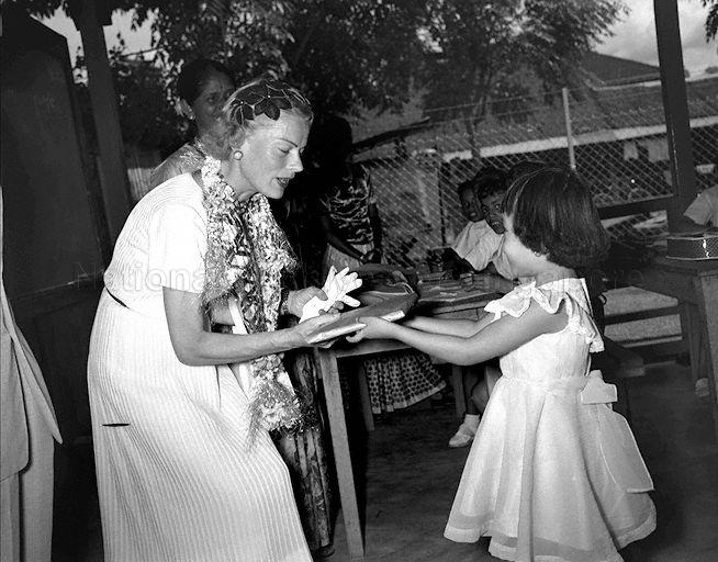 Wife of Colonial Secretary Lady Patricia Lennox Boyd being presented with a gift from six-year old Elsie Koh during her visit to Joo Chiat Community Centre