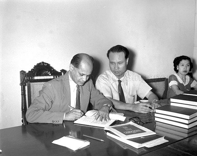 Chairman of the Malayanisation Commission Dr B R Sreenivasan signing the report on Malayanisation of the Singapore Government Service