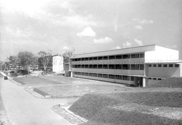 The school in the foreground is the Marsiling Primary School while the building in background houses the quarters for married ratings (non-commissioned officers or petty officers) of the Royal Malayan Navy. 
