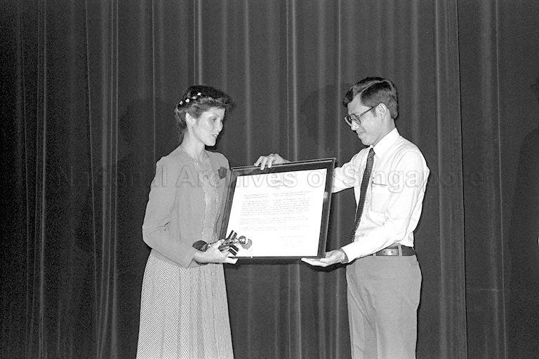 Madam Yan Choong Lian (left), 29, assistant choreographer with the National Dance Company, receiving the National Youth Service Award from Minister of State for National Development Lee Yock Suan (right) at Penthouse Negara, National Development Building. She helped form the Kampung Glam community centre dance troupe in 1975. Madam Yan, the group's choreographer, producer, director, person-in-charge, was also helping schools and other groups like the National Theatre Club.
