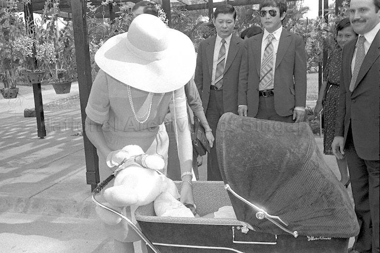 Queen Noor Al-Hussein, wife of King Hussein Ibn Talal of Jordan, turning her attention to four-month-old daughter Princess Iman Al-Hussein, during a tour of Botanic Gardens.