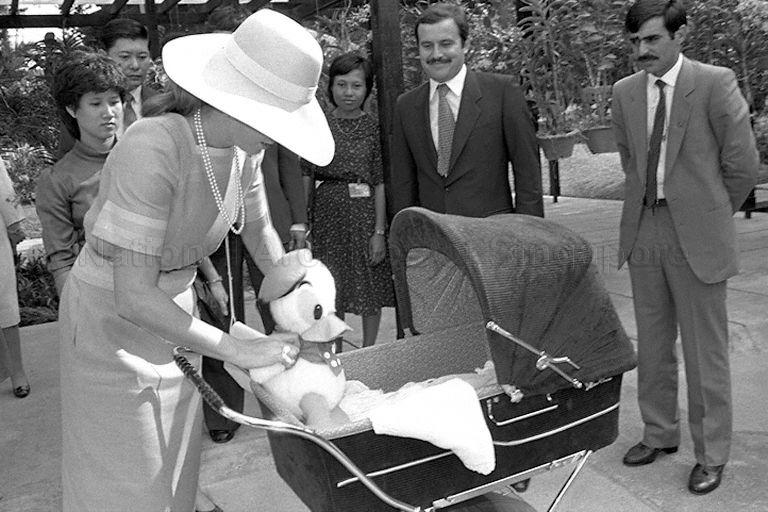 Queen Noor Al-Hussein, wife of King Hussein Ibn Talal of Jordan, turning her attention to four-month-old daughter Princess Iman Al-Hussein, during a tour of Botanic Gardens.