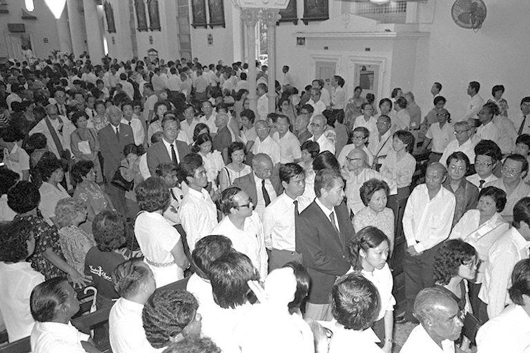 Acting President Dr Yeoh Ghim Seng, Prime Minister Lee Kuan Yew and First Deputy Prime Minister Dr Goh Keng Swee leaving the Cathedral of the Good Shepherd for Mount Vernon Crematorium. Also present are a number of Mr Hon's Cabinet colleagues, junior ministers, Members of Parliament (MPs), top civil servants, diplomats, other VIPs and serval Catholic nuns and brothers.