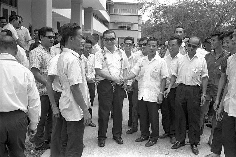 General Election candidate (garlanded) exchanging handshakes with supporter at Monk's Hill Secondary School on Nomination Day