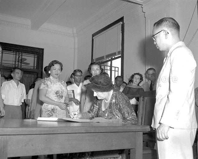 Lady Dorothy Macmillan, wife of British Prime Minister, signing guest book at Singapore's City Hall. Looking on from left are Mrs Lim Yew Hock, wife of Chief Minister, and Mrs Ong Eng Guan, Mayor of Singapore.