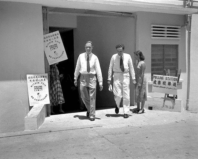 Colonial Secretary William AC Goode (left) at a polling station