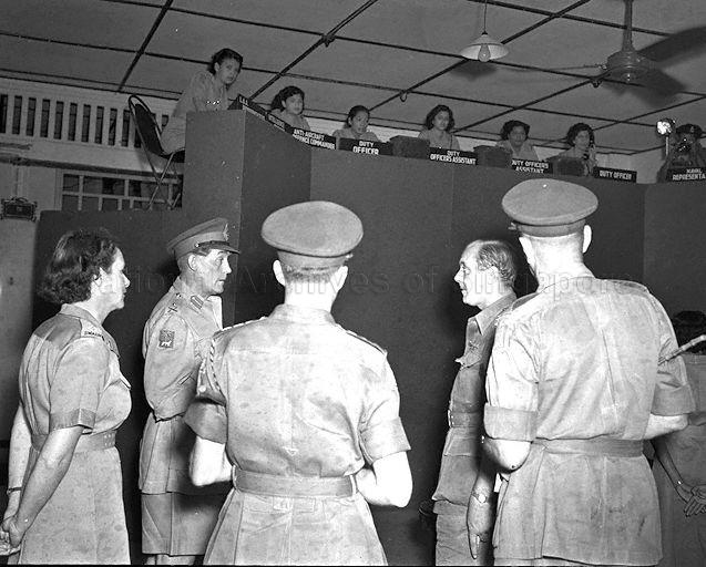 General Officer Commanding of Singapore Base District Major-General A G O'Carroll Scott (second from left) chatting with army officers at the controlling-reporting operation room during his visit to Singapore Volunteer Corps