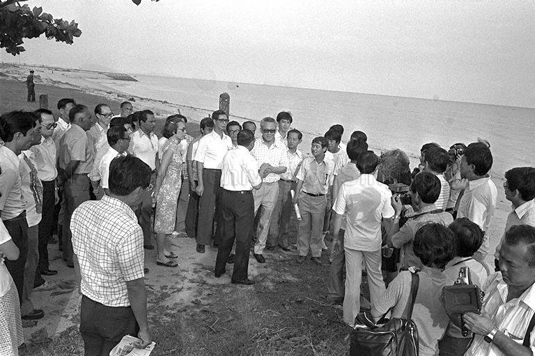 Prime Minister Lee Kuan Yew being briefed by Minister for National Development (MND) Teh Cheang Wan (back to camera, beside Mr Lee) on the reclaimed beach at East Coast Park. The Prime Minister and Mrs Lee were touring the park after Mr Lee planted a sea putat for Tree Planting Day.