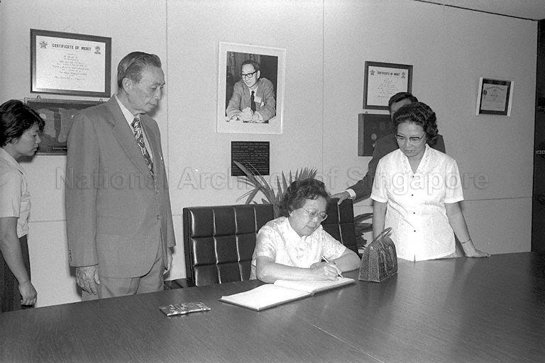 Madam Cho Lin, wife of the People's Republic of China (PRC) Senior Vice-Premier Teng Hsiao-Ping signing the guest register when she arrives for a visit to Jurong Bird Park. Looking on are Director of Jurong Bird Park Woon Wah Siang (left) and Madam Ho Li-Liang (right), wife of the PRC Foreign Minister Huang Hua. The Senior Vice-Premier is on a three-day visit to Singapore as part of a three-nation tour of South-East Asia that includes Thailand, Malaysia and Singapore.