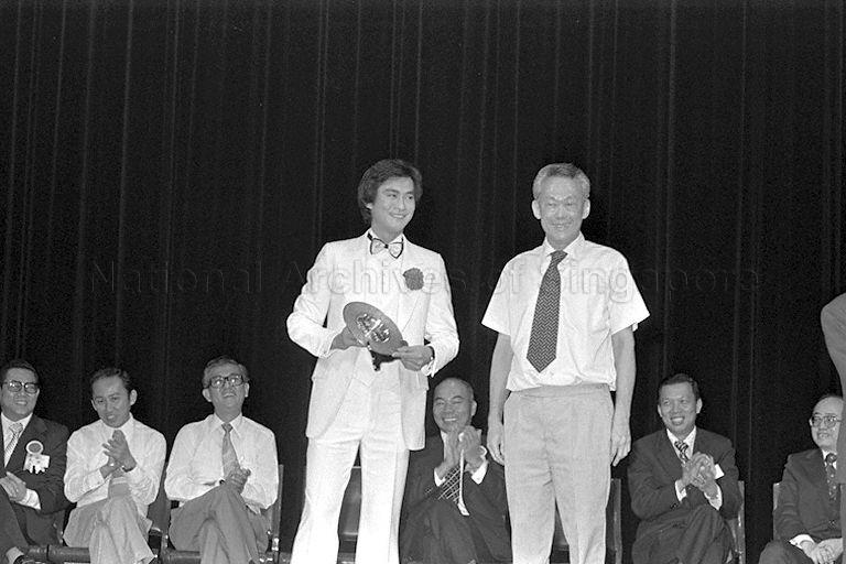 Prime Minister Lee Kuan Yew posing for photograph with Hong Kong actor Adam Cheng after presenting the latter with a plaque for his participation in Cantonese opera performance staged by the Hoi Thin Amateur Dramatic Association at the National Theatre. The event is in aid of fund-raising efforts for Tanjong Pagar Community Centre's building extension project.