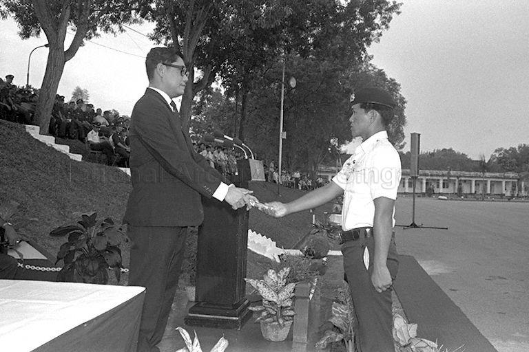 Lo Kok Peng, one of the seven best trainees of the first intake of police national servicemen, receiving a prize award from Minister of Home Affairs Chua Sian Chin during the first passing out parade at Police Academy in Thomson Road.