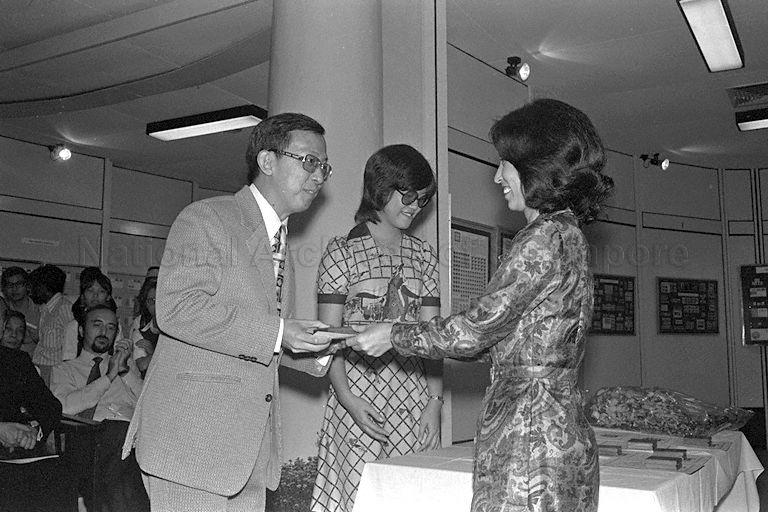 Businessman Tay Peng Hian (foreground, left) receiving the gold medal award from Mrs Ong Teng Cheong (right), wife of Senior Minister of State for Communications, during the opening of the Seventh National Stamp Exhibition - Singpex '75 at the Victoria Memorial Hall. His entry on a comprehensive study of Straits Settlements stamps from 1854 to 1899 and its postal history up to 1900 was responsible for winning the philatelic "Oscar".