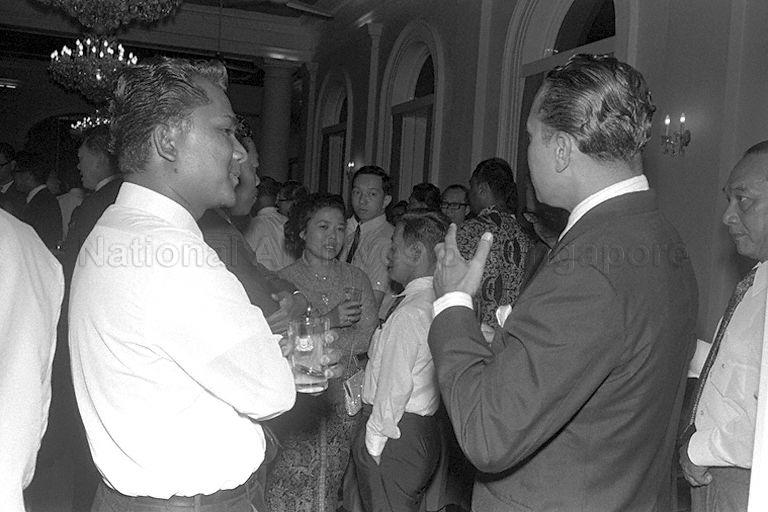 Prime Minister Lee Kuan Yew (background, left), Senior Parliamentary Secretary to Ministry of Culture Sha'ari Bin Tadin (centre left), and Minister for Social Affairs Othman Bin Wok (second from right) mingling with community leaders during a Chinese New Year reception at Istana.