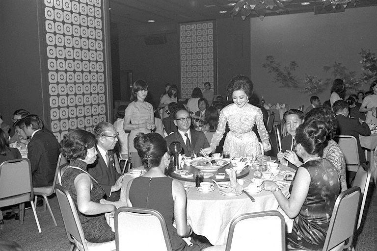 Hong Kong actress Lily Ho (standing) at the table with (clockwise from her) Minister for Culture Jek Yeun Thong (first), Mrs Peggy Shaw (second, partly hidden), Mrs Jek (fifth), and Runme Shaw (sixth) of Shaw Brothers, who is also chairman of the Tourist Promotion Board, during a dinner reception for artistes, directors and producers in the 19th Asian Film Festival.
