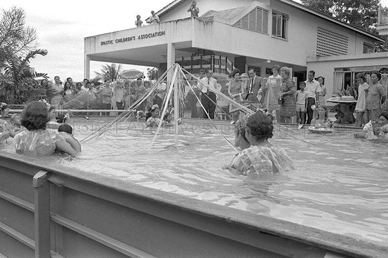 First Lady Mrs Benjamin Henry Sheares (background, centre) watching a water ballet demonstration by eight children of Spastic Children's Association of Singapore after its 13th annual sports meet at Field House, 25 Gilstead Road.