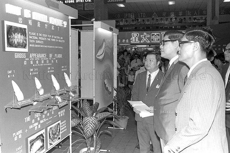 Minister for Health and Home Affairs Chua Sian Chin (foreground, second from right) touring the Dental Health Exhibition organised by the Dental Health Education Unit at People's Park Complex after its opening ceremony. He is accompanied by Senior Dental Officer of Training and Dental Health Education Wong Hee Deong (foreground, right).