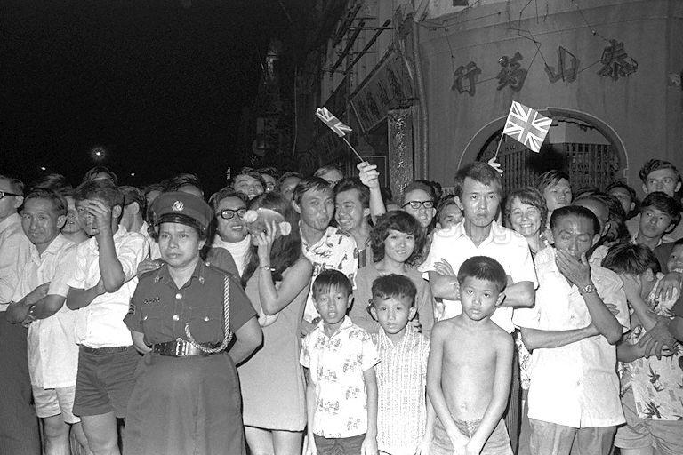 Crowd in front of Thye Shan Medical Hall at the junction of Pagoda Street and New Bridge Road, waiting for the arrival of Queen Elizabeth II when she tours Chinatown