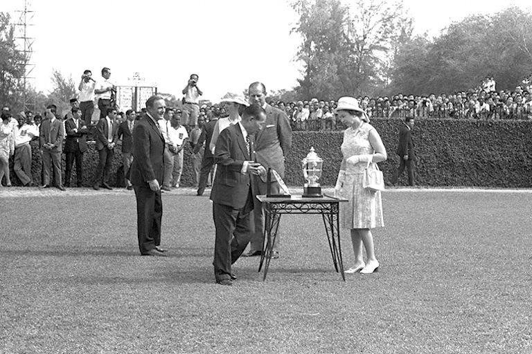 Queen Elizabeth II arriving to present prizes of Queen Elizabeth II Cup at Singapore Turf Club in Bukit Timah. She is accompanied by (from right to left) Duke of Edinburgh Prince Philip, club chairman Tan Sri Runme Shaw, Princess Anne and club secretary D R H Brown.