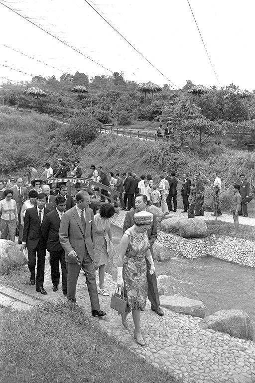 Queen Elizabeth II and Duke of Edinburgh Prince Philip, accompanied by Chairman and Managing Director of Jurong Bird Park Woon Wah Siang, touring the bird park during their three-day state visit to Singapore
